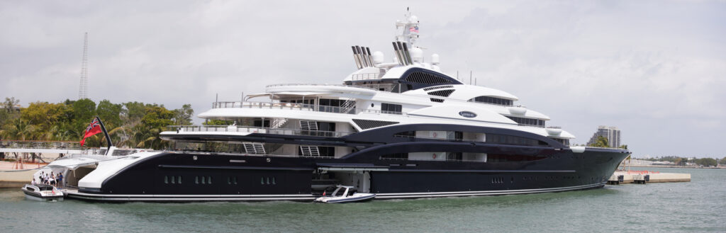 Serene, a ship with a striking mostly black hull with stark white accents, sits moored at a dock in Miami, Florida.